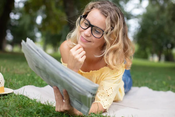 Ung Affärskvinna Läsa Tidningen Medan Liggande Gräs Parken — Stockfoto
