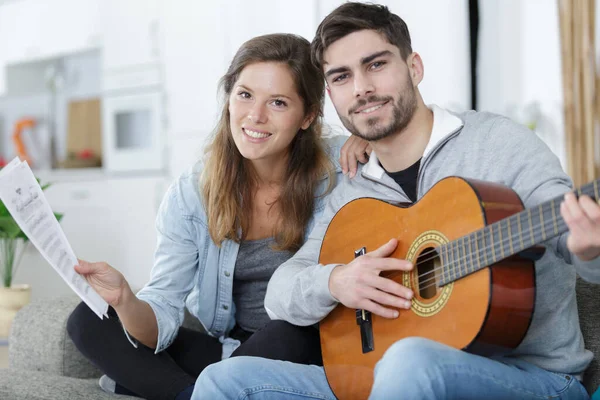 女性はギターを弾く男性のための音楽を持ち — ストック写真