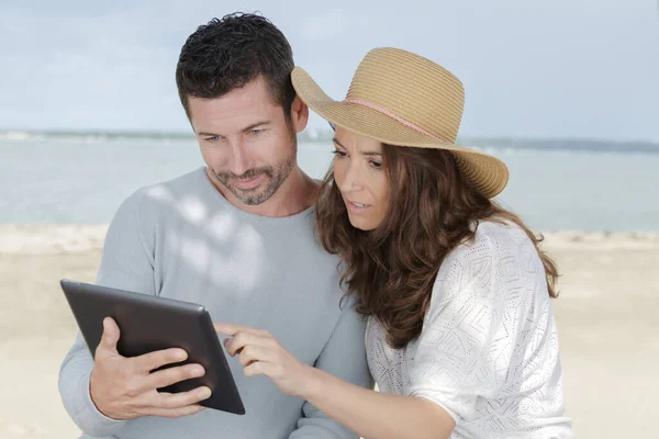 Ζευγάρι Που Χρησιμοποιεί Tablet Στην Παραλία — Φωτογραφία Αρχείου