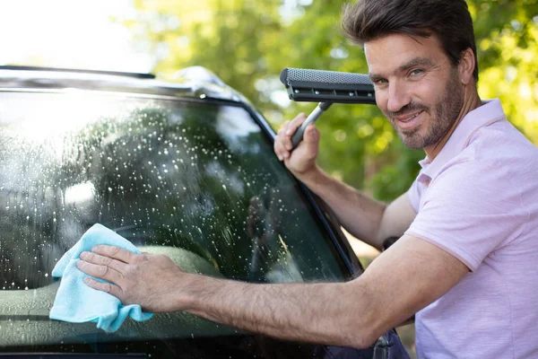 Homem Feliz Segurando Squeegee Enquanto Limpando Janela Carro — Fotografia de Stock