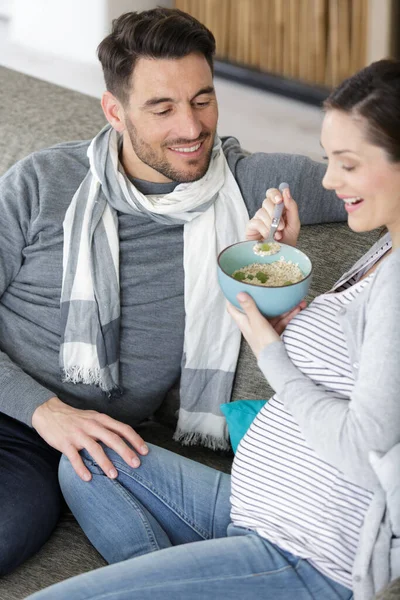 彼氏の隣で食べる妊婦さん — ストック写真