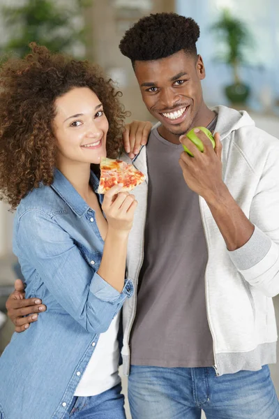男はリンゴを食べ女はピザを食べる — ストック写真