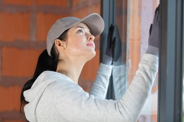 Genç Kadın Usta Modern Pencere Çerçevesine Bakıyor — Stok fotoğraf