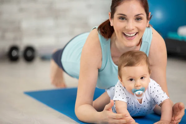 athletic mother exercising in plank position