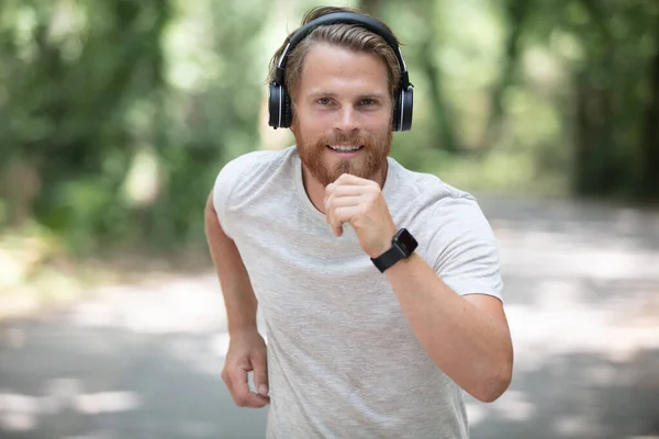 Atlético Hombre Está Corriendo Usando Smartwatch Auriculares —  Fotos de Stock