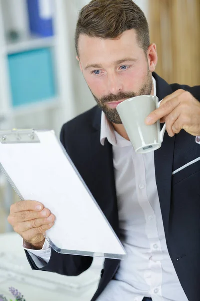 Affärsman Som Håller Urklipp Och Kaffekopp — Stockfoto