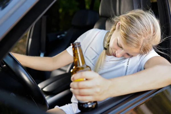 司机座位上拿着一瓶酒的女人 — 图库照片
