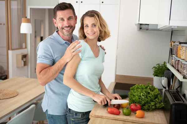 Mężczyzna Przytulanie Kobieta Podczas Ona Kroić Warzywa — Zdjęcie stockowe