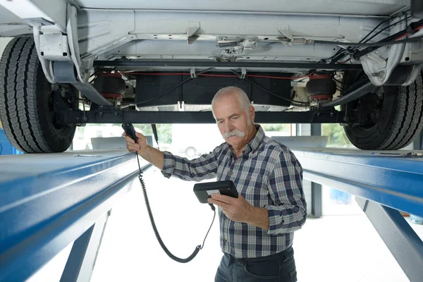 Starszy Mechanik Sprawdza Stan Techniczny Pod Samochodem — Zdjęcie stockowe