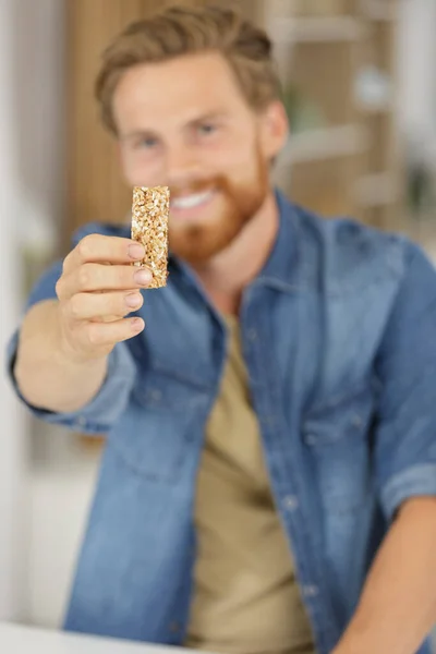 Hombre Mostrando Barra Cereal Sin Envolver —  Fotos de Stock