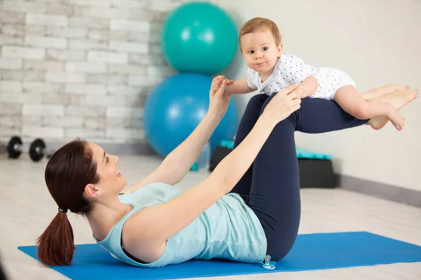 Woman Exercising Balancing Her Baby Her Legs — Stock Photo, Image