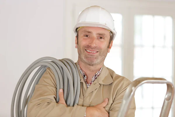 Middle Aged Builder Reel Grey Conduit His Shoulder — Stock Photo, Image