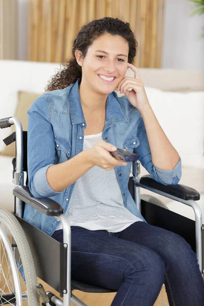 Γυναίκα Αναπηρική Καρέκλα Αλλαγή Τηλεοπτικών Καναλιών — Φωτογραφία Αρχείου