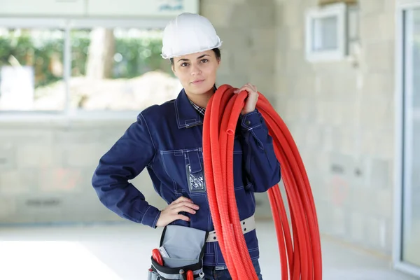 Mulher Trabalhador Segurando Carretel Tubo Vermelho Seu Ombro — Fotografia de Stock