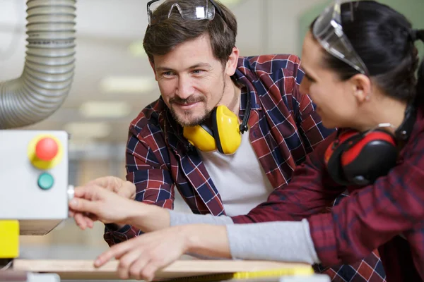 Stock image man and woman checking machine in factory