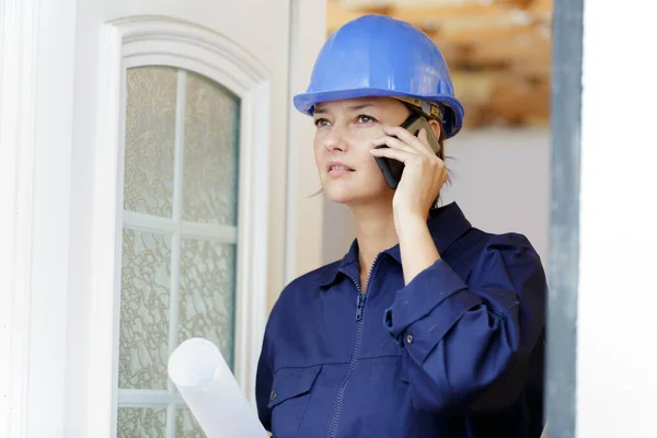 建設現場で携帯電話を使う女性技術者は — ストック写真