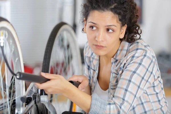 小さなハンドポンプで自転車のタイヤを汲み上げる女性は — ストック写真
