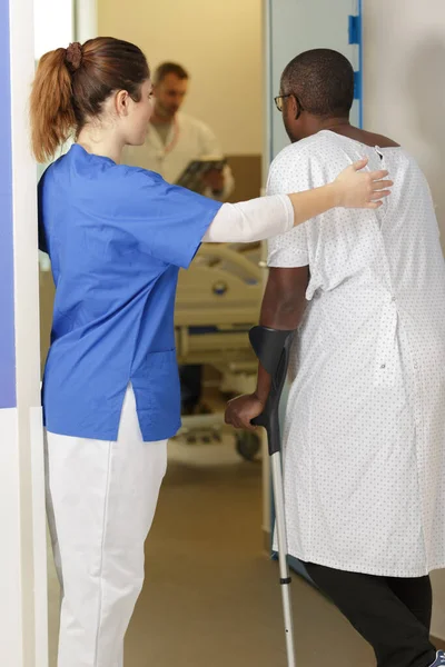 Männlicher Patient Mit Krücken Bekommt Hilfe Von Krankenschwester — Stockfoto