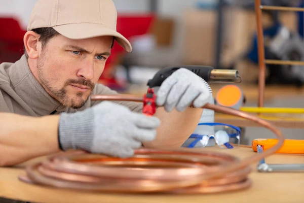 Young Plumber Cutting Copper Pipe — Stock Photo, Image