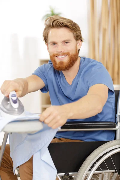Behinderter Mann Rollstuhl Bügelt Kleidung — Stockfoto