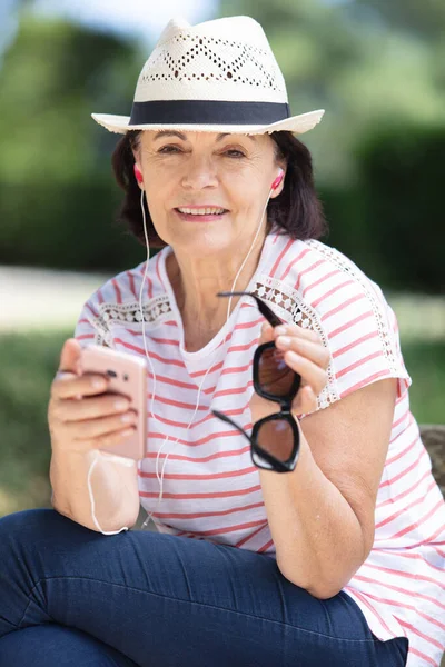 Ηλικιωμένη Γυναίκα Που Ακούει Ακουστικά Συνδεδεμένα Smartphone — Φωτογραφία Αρχείου