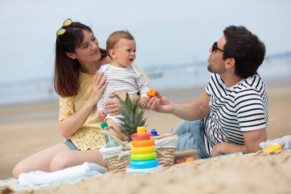 一对夫妇和一个3个月大的婴儿在海滩上 — 图库照片