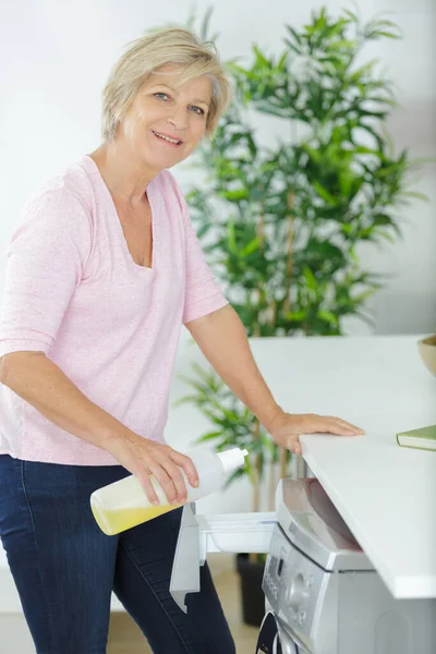 Mujer Mayor Cargando Lavadora Casa —  Fotos de Stock