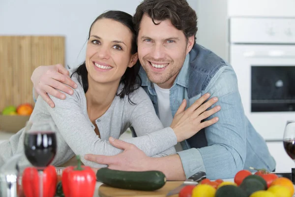 木のテーブルの上で野菜を抱きかかえてかわいいカップル — ストック写真