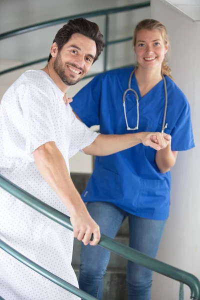 Заботливая Медсестра Помогает Пациенту Спускаться Лестнице — стоковое фото