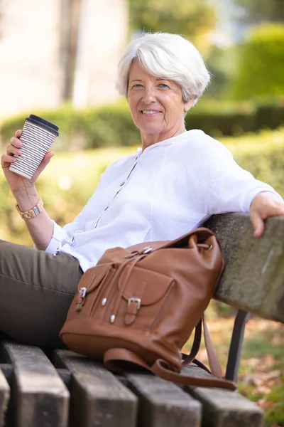 老年妇女在公园长椅上休息 — 图库照片
