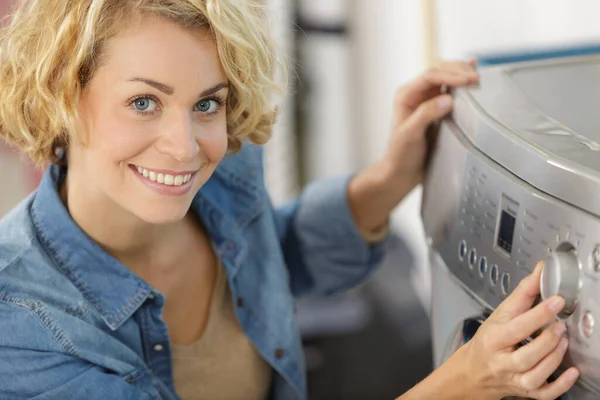 女人在洗衣机上转动刻度盘 — 图库照片