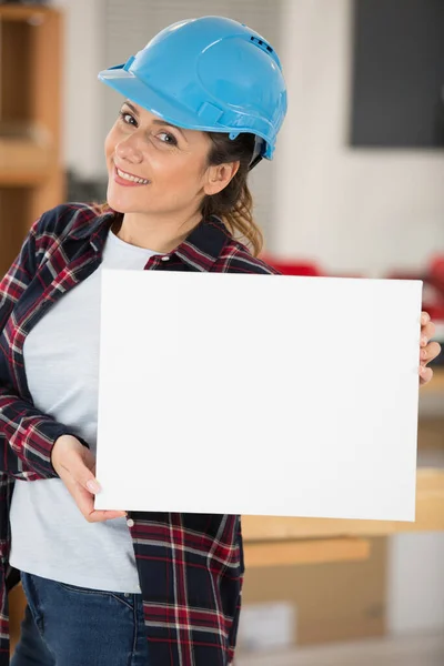 白い板を持った若い女性建設労働者は — ストック写真