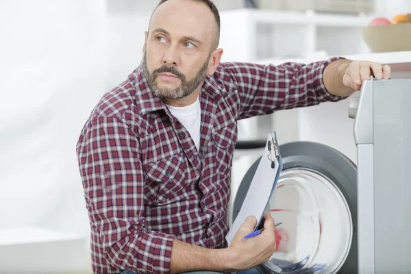 Çamaşır Makinesinin Yanında Panosu Olan Bir Tesisatçı — Stok fotoğraf