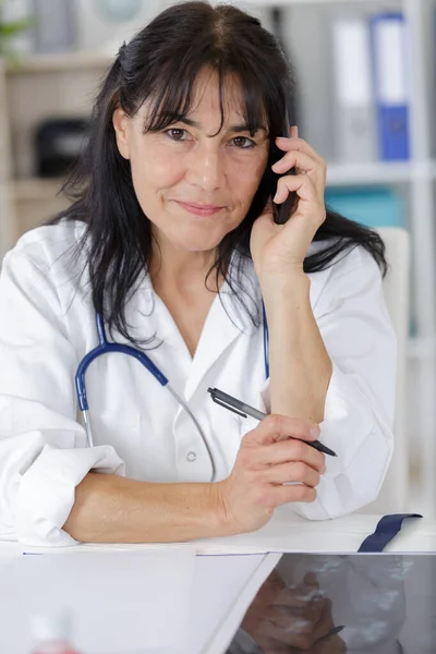 一个微笑的医生妇女在电话里 — 图库照片