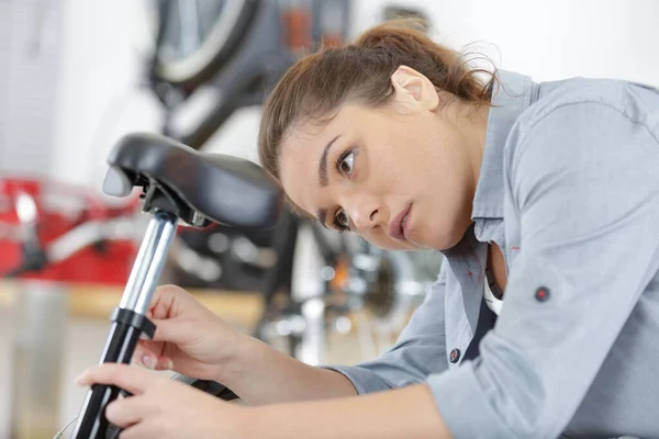 Kvinnlig Cykelmekaniker Som Reparerar Cykelsadel — Stockfoto