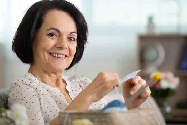 Alegre Sonriente Senior Mujer Tejiendo Sofá Casa —  Fotos de Stock