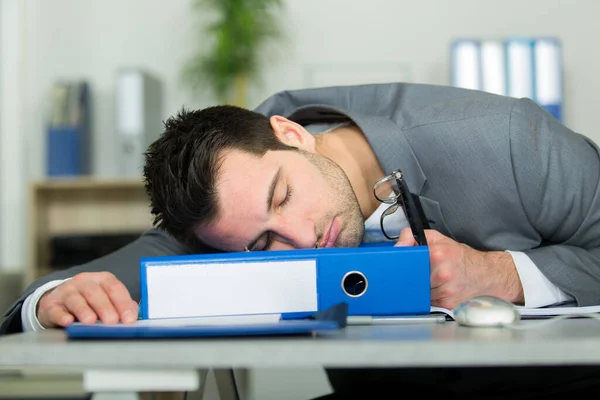 机の上に寝ている疲れのビジネスマン — ストック写真