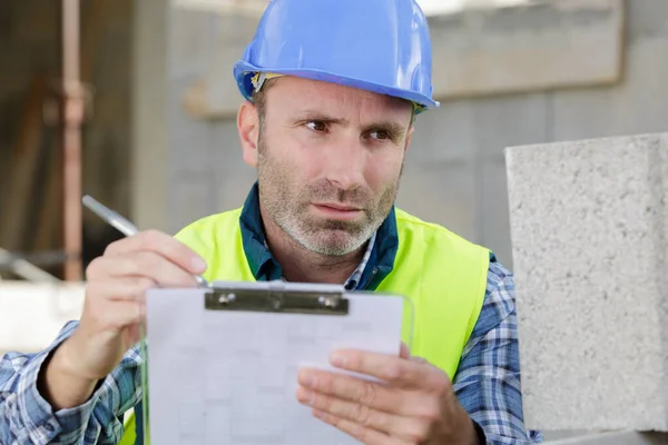 Male Builder Checking Construction Papers — Stock Photo, Image