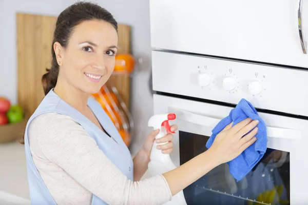 Щаслива Жінка Прибирає Піч Домашній Кухні — стокове фото