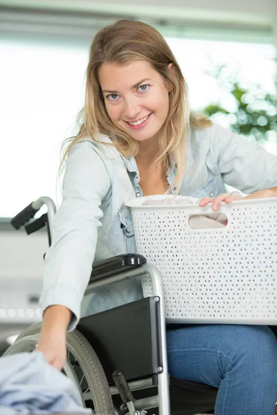 Onnellinen Nainen Pyörätuolissa Pyykkäämässä — kuvapankkivalokuva