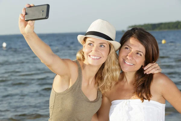 Dos Amigas Tomando Selfie Con Mar Detrás Ellas —  Fotos de Stock