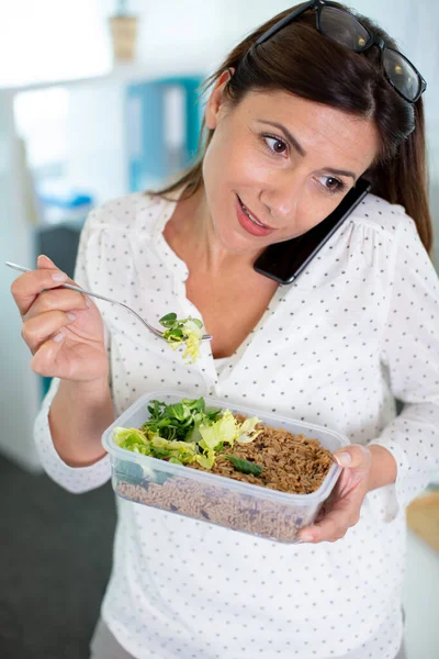 Mulher Escritório Comendo Salada Enquanto Telefone — Fotografia de Stock