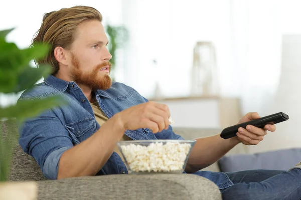 Mężczyzna Popcornem Pilotem Patrzy Telewizor — Zdjęcie stockowe