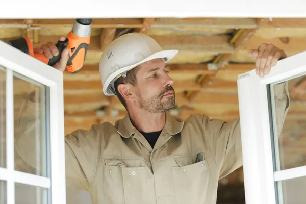 Ein Männlicher Bauunternehmer Überprüft Fenster — Stockfoto