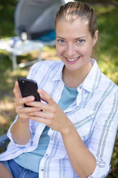 Mulher Usando Smartphone Enquanto Acampando Fora — Fotografia de Stock
