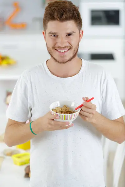 Joven Guapo Comiendo Cereal Sonriendo Cocina —  Fotos de Stock