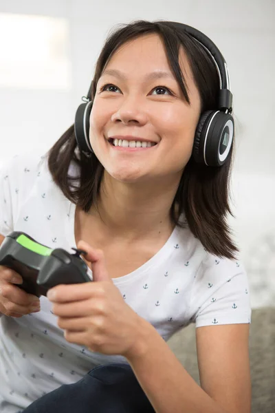 Żeński Gracz Noszący Słuchawki Pomocą Kontrolera Bezprzewodowego — Zdjęcie stockowe