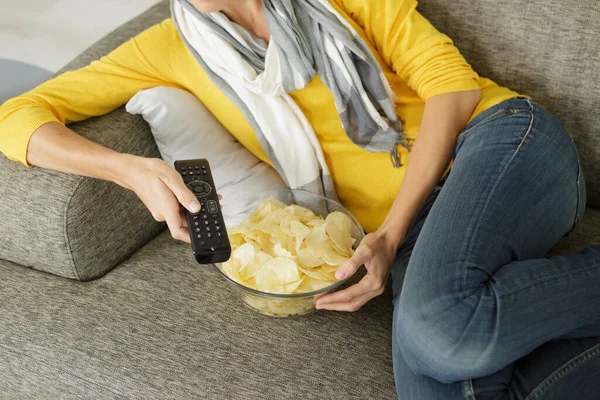 picture of woman holding bowl of chips and remote control