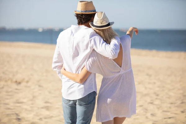 Estilo Vida Casal Sênior Abraço Apontando Praia — Fotografia de Stock