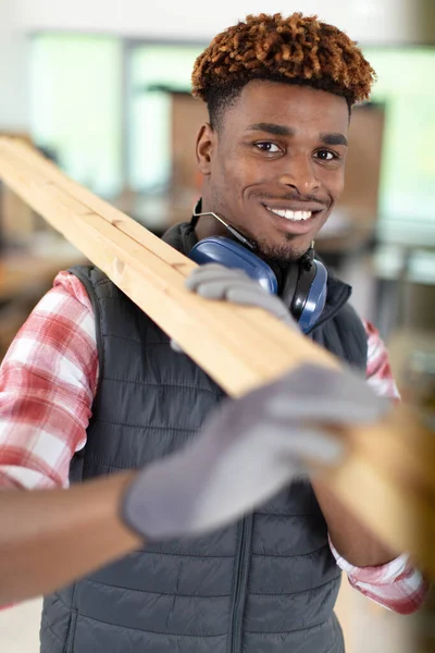 Young Male Worker Carrying Tied Wooden Planks Construction Site — Stock Photo, Image